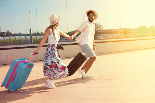 Happy young couple landed at the airport, arrived at the destination of vacation Happy young couple landed at the airport, arrived at the destination of vacation