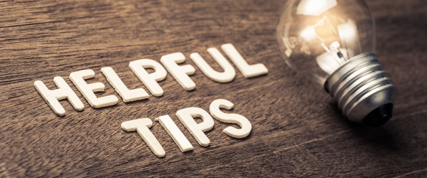 Schriftzug Helpful Tips neben einer leuchtenden Glühbirne.
